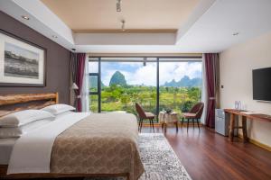 1 dormitorio con cama grande y ventana grande en Guilin Village Creek Inn, en Guilin