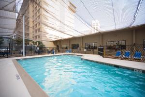 a large swimming pool with blue water in a building at Iconic Vegas Views - 6 comfy Beds, NO RESORT FEES, Center Strip! in Las Vegas