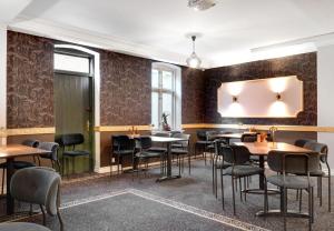 restauracja ze stołami i krzesłami oraz lustrem na ścianie w obiekcie Hotel Ringkøbing w mieście Ringkøbing