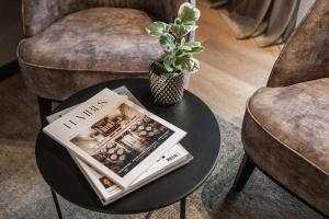 einen Tisch mit einer Zeitung und einer Topfpflanze darauf in der Unterkunft Hotel Britannia in Knokke-Heist