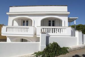 een wit huis met een balkon bij Appartamenti in Via Schipa Pescoluse in Marina di Pescoluse