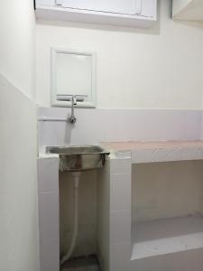 een badkamer met een wastafel en een spiegel bij Ellys home stay in Guwahati