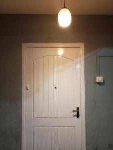 een witte deur in een kamer met een licht bij Ellys home stay in Guwahati