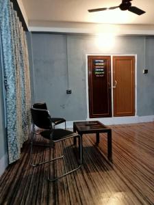 een kamer met een stoel, een tafel en een deur bij Ellys home stay in Guwahati