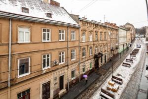 a group of buildings in a city with snow at Romari Лесі Українки in Lviv