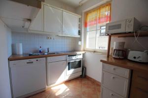 eine Küche mit weißen Schränken und einem Waschbecken in der Unterkunft Apartment Am Stubnitzwald in Sassnitz