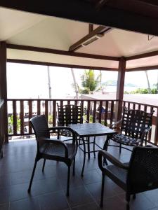 a patio with a table and chairs on a balcony at Sandy Beach Resort By Casa Loma in Pantai Cenang