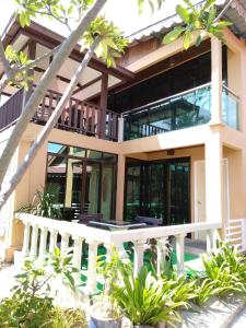 a large house with a porch and a balcony at Sandy Beach Resort By Casa Loma in Pantai Cenang