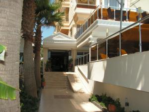 a white house with a staircase and palm trees at Amphora Hotel in Ayvalık