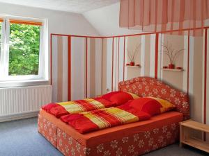 a bed in a room with a red and yellow blanket at Ferienwohnung Seeluster Bucht in Plötzenhöhe