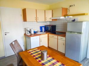 a small kitchen with a table and a refrigerator at Ferienbungalow Stahlbrode in Stahlbrode