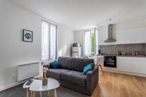 salon z kanapą i kuchnią w obiekcie Le Musée 1, Cosy 2 pièces w mieście Bergerac