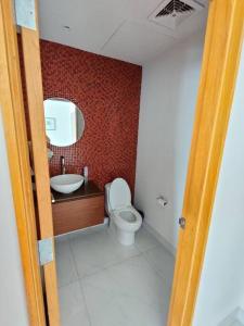 W łazience znajduje się toaleta, umywalka i lustro. w obiekcie Penthouse liu east piso 35 valle oriente w mieście Monterrey