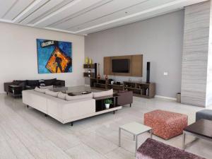 sala de estar con sofá y TV en Penthouse liu east piso 35 valle oriente en Monterrey