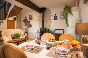 Le Sarcinoé في Sergines: غرفة طعام مع طاولة مع فاكهة عليها
