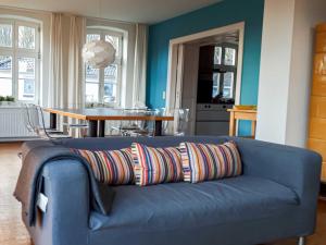 a blue couch with a colorful pillow on it in a living room at Apartment Klausdorf in Klausdorf Mecklenburg Vorpommern
