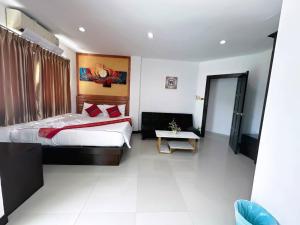 a bedroom with a large bed and a table at Abby's House Hotel in Patong Beach
