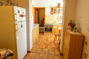 a kitchen with a white refrigerator and a wooden floor at Ferienwohnung an der Drei-Kaiser-Eiche in Freest