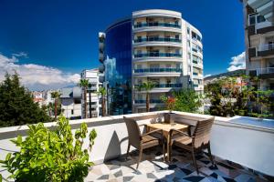 a table and chairs on a balcony with a building at 8 Rooms House in Balcova