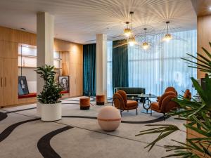 eine Lobby mit Stühlen und einem Tisch in einem Gebäude in der Unterkunft Mercure La Rochelle Vieux Port in La Rochelle