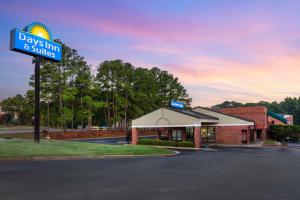 un cartello per una locanda e suite di Days Inn & Suites by Wyndham Rocky Mount Golden East a Rocky Mount