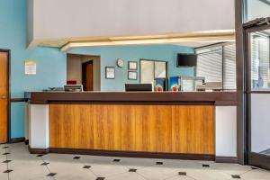 a reception desk in an office with a mirror at Days Inn & Suites by Wyndham Rocky Mount Golden East in Rocky Mount