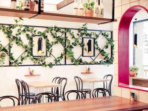 Mercure Perth في بيرث: مطعم بطاولات وكراسي على جدار مع اللبي