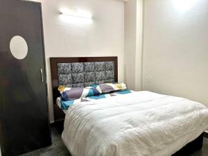 a bedroom with a large bed with pillows on it at 2 Bhk apt near Manipal hospital by RDBL Hospitality Private limited in New Delhi