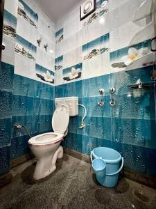 a blue bathroom with a toilet and two buckets at 2 Bhk apt near Manipal hospital by RDBL Hospitality Private limited in New Delhi