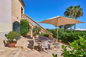 a table and chairs with an umbrella on a patio at Finca Tanca in Calonge