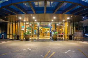 a building with glass doors and potted plants in front at THE 1O1 Jakarta Sedayu Darmawangsa in Jakarta