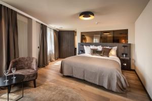 a hotel room with a bed and a chair at Hotel Britannia in Knokke-Heist