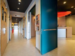 a hallway with a blue refrigerator in a building at Ibis Madrid Centro las Ventas in Madrid