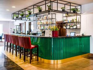 a green bar with a row of red chairs at Dosłońce Resort Wellness & Farm in Racławice