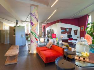ein Wohnzimmer mit einem roten Sofa und einem Tisch in der Unterkunft ibis Styles Catania Acireale in Acireale
