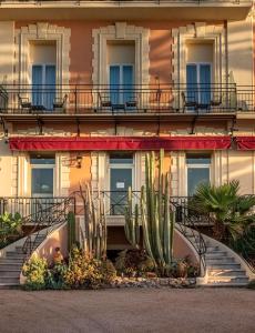 un edificio con escaleras y cactus delante en Best Western Premier Hotel Prince de Galles, en Menton