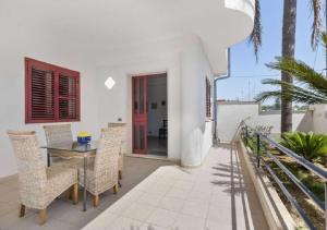 イスピカにあるVilla Rosimeli con Piscina a 150 mt dal mareのバルコニーにテーブルと椅子が置かれたダイニングルーム