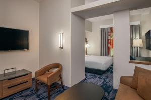 une chambre d'hôtel avec un lit, un canapé et une télévision dans l'établissement Fairfield Inn & Suites by Marriott Brunswick Freeport, à Brunswick