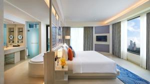 a bedroom with a large bed and a bathroom at Amari Pattaya in Pattaya Central