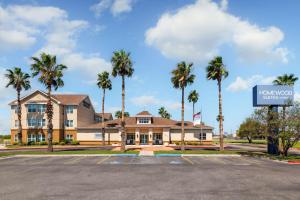 a hotel with palm trees in front of a parking lot at Homewood Suites by Hilton Corpus Christi in Corpus Christi