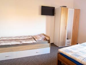 a bedroom with a bed and a cabinet with a tv at Ferienhaus mit maritimer Einrichtung in Kröslin