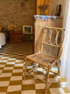 una silla de mimbre en una habitación con suelo a cuadros en Priçosa Perfect Apart Cyclists&Travellers, en Girona