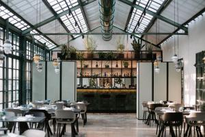 a restaurant with tables and chairs in a room with windows at Relais Roncolo 1888 in Quattro Castella