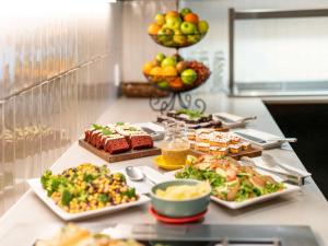 a buffet with different types of food on a table at Mercure Wellington Abel Tasman Hotel in Wellington