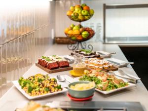 um buffet com diferentes tipos de alimentos sobre uma mesa em Mercure Wellington Abel Tasman Hotel em Wellington