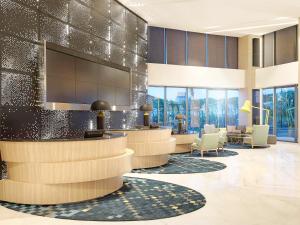 a lobby with a waiting area with chairs and a salon at Novotel Samator Surabaya Timur in Surabaya