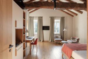 a hotel room with a bed and a desk and chairs at Relais Roncolo 1888 in Quattro Castella