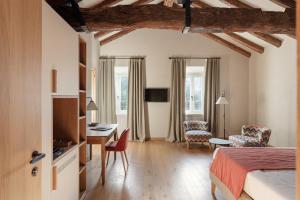 a hotel room with a bed and a desk and chairs at Relais Roncolo 1888 - Small Luxury Hotels of the World in Quattro Castella
