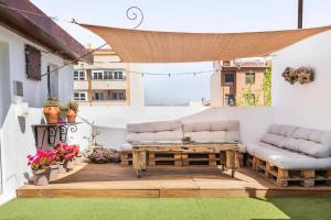 eine Terrasse mit 2 Sofas und einem Holztisch in der Unterkunft Wood&Stone Rooms in Yecla