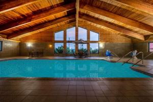 a swimming pool in a building with a wooden ceiling at AmericInn by Wyndham Eau Claire in Eau Claire